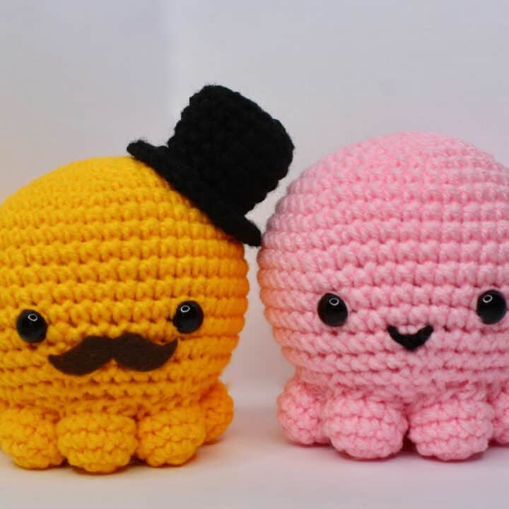 A yellow octopus with a hat and mustache with a pink octopus.
