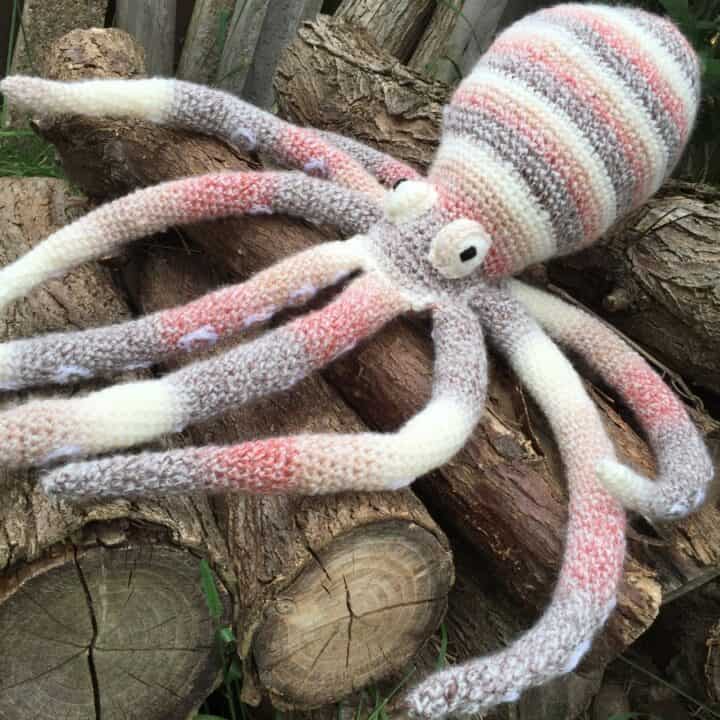 A large octopus amigurumi on top of wooden logs.
