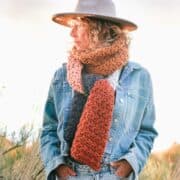 Woman wearing a chunky crocheted scarf.