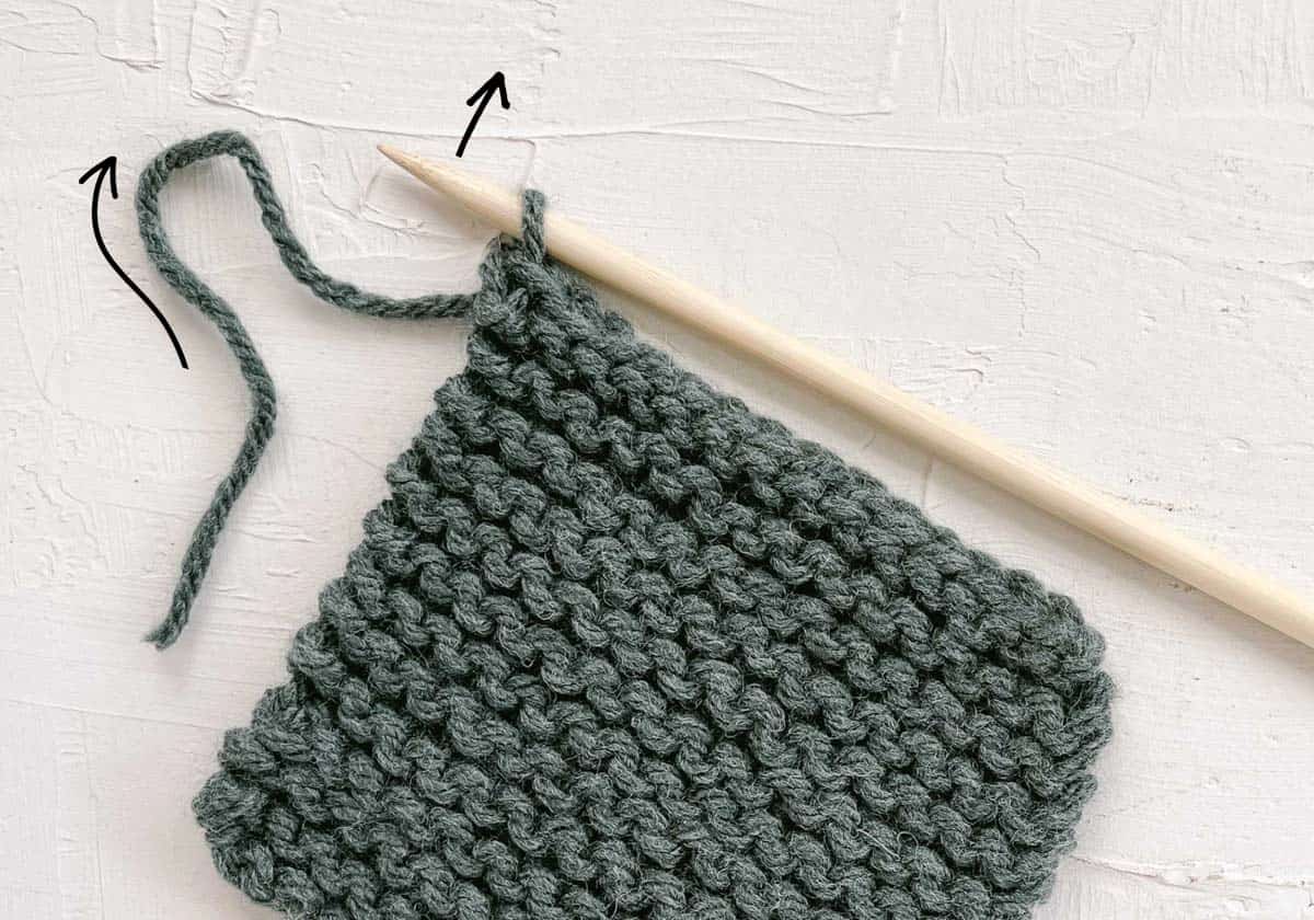 How to fasten off knitting by pulling on yarn tail.