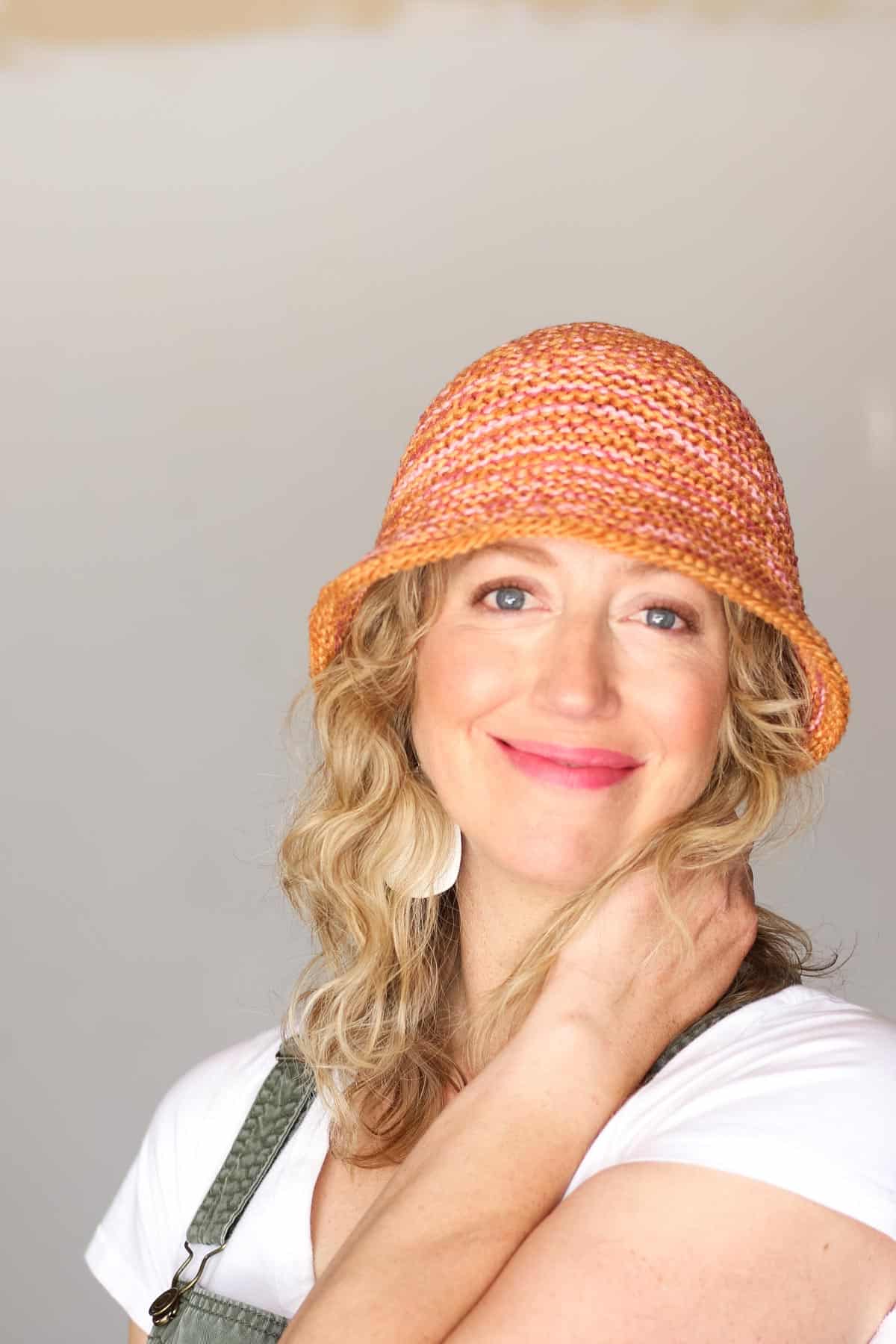 A woman smiling at camera wearing a knitted bucket hat.