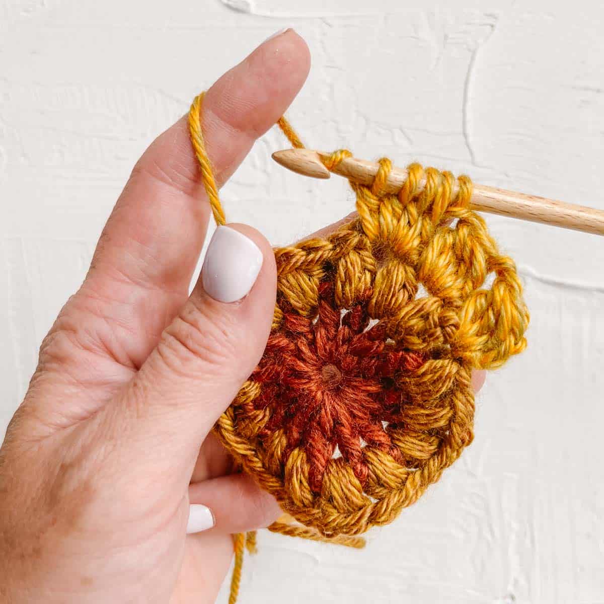 Double crochet cluster stitch worked into a sunburst granny square.