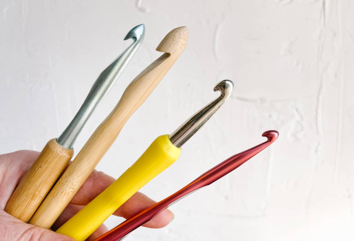 Four crochet hooks made of bamboo, aluminum and steel.