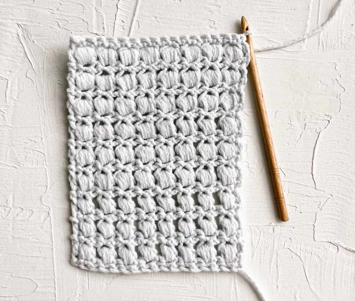 The backside of a swatch of crochet puff stitches.