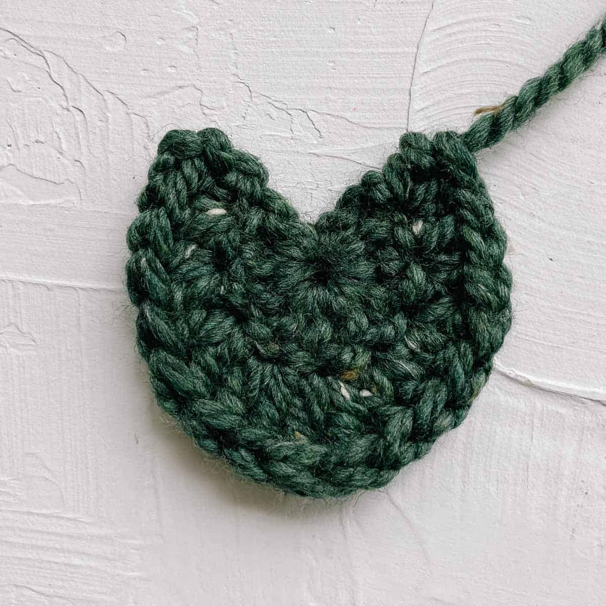 A green pumpkin leaf crocheted with chunky yarn.