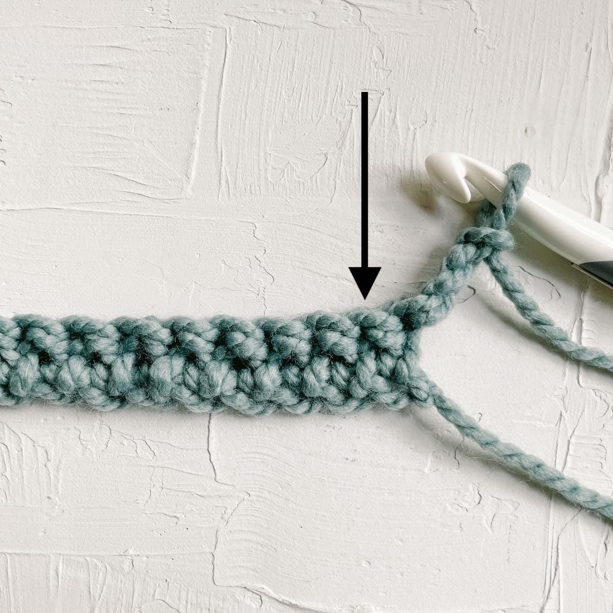 Arrow pointing to placement of first stitch in blanket row.