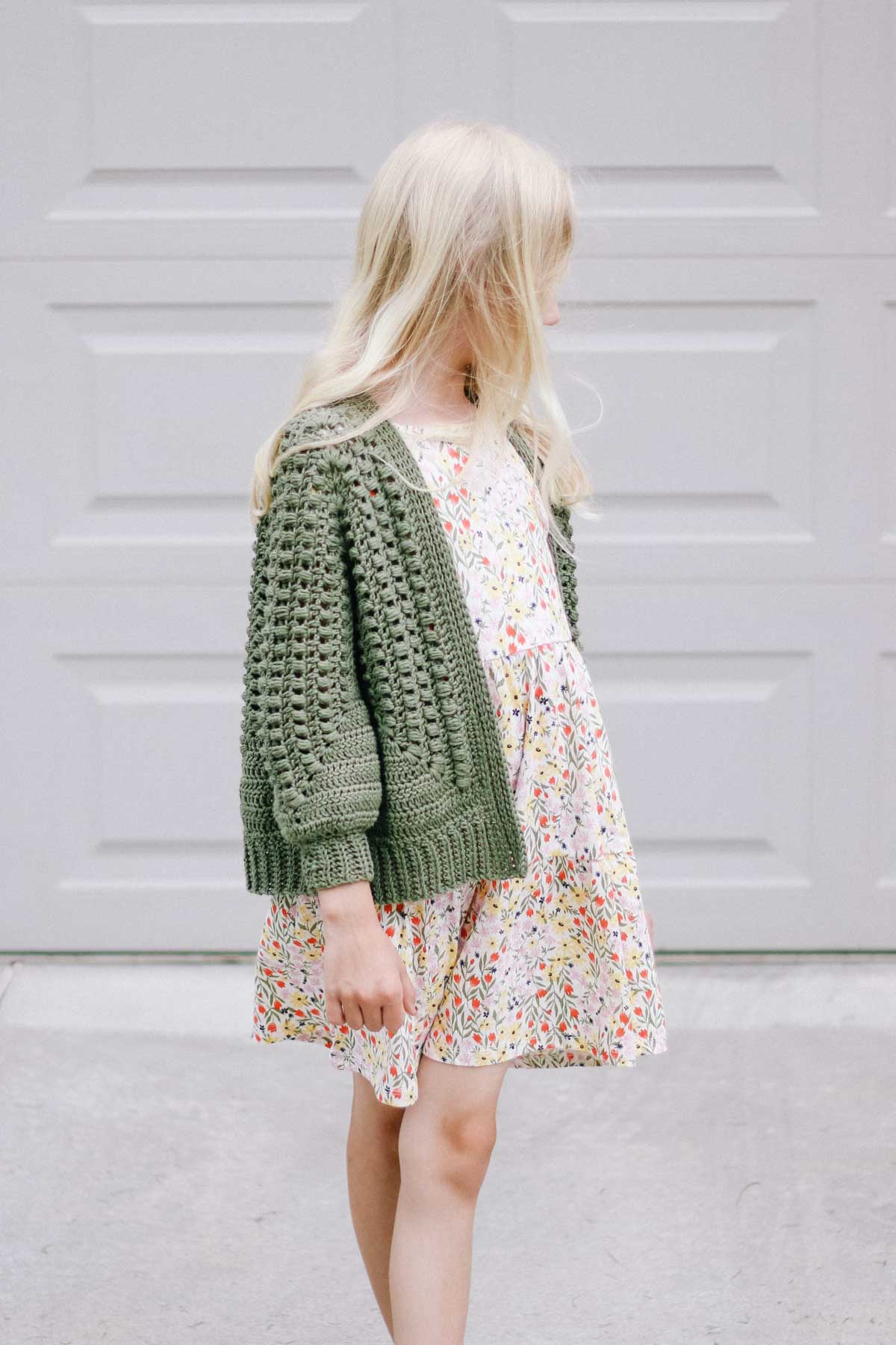 8-year-old girl wearing a cute crochet cardigan.