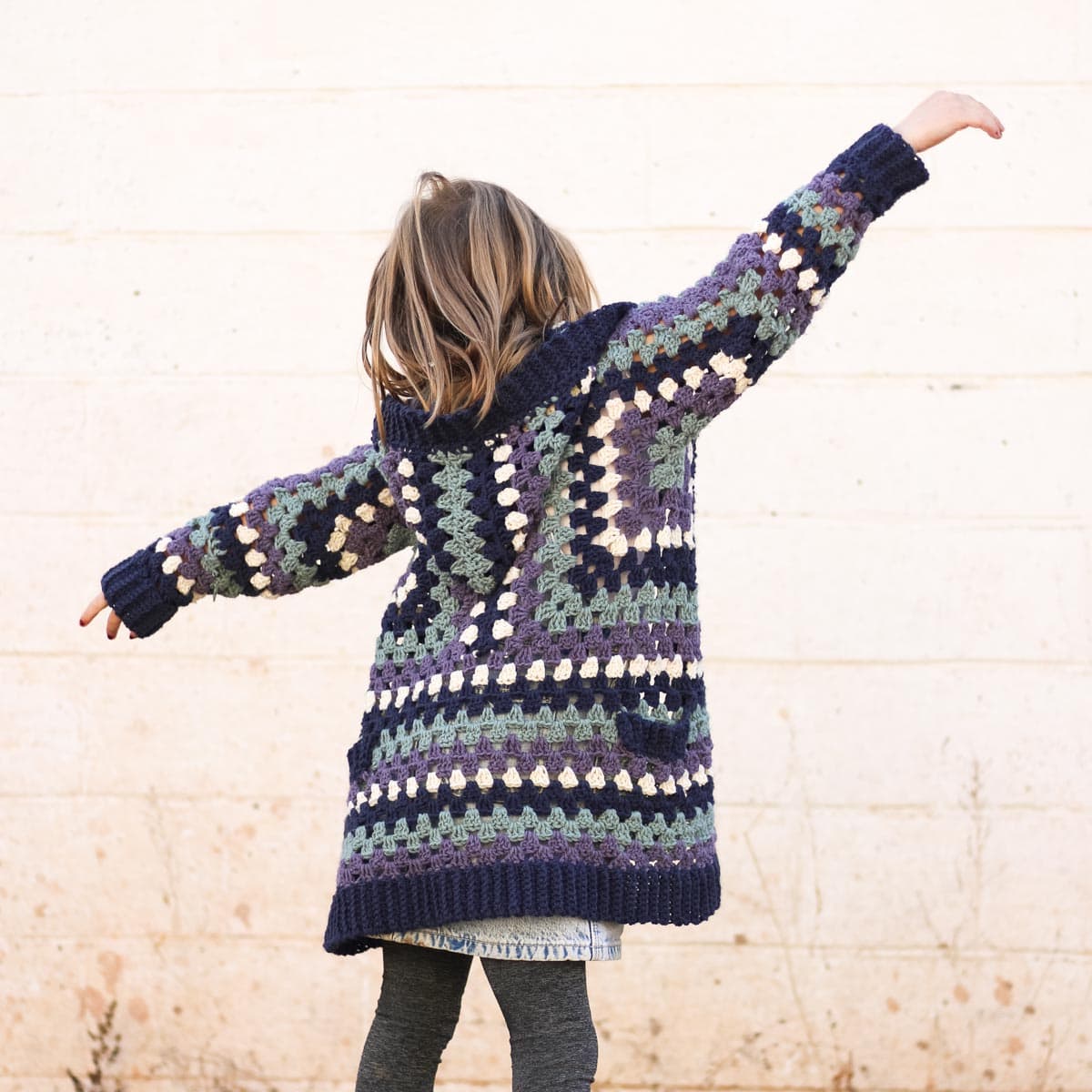 Child with back to camera wearing a granny stitch hexagon cardigan.
