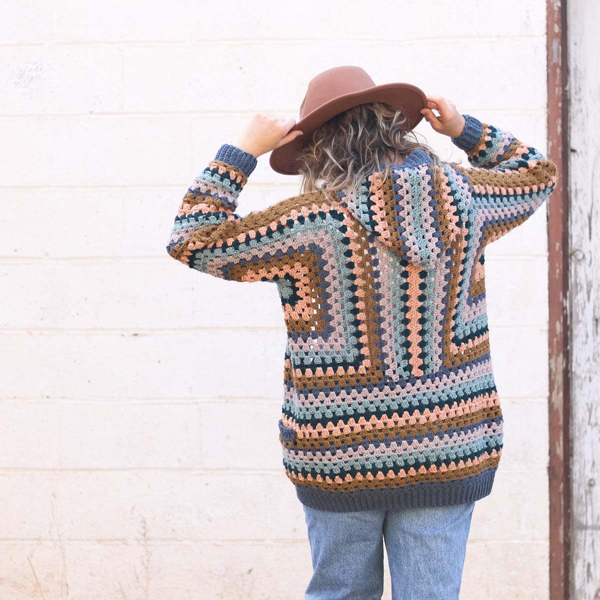 Woman with back to camera wearing a crochet hexagon cardigan.