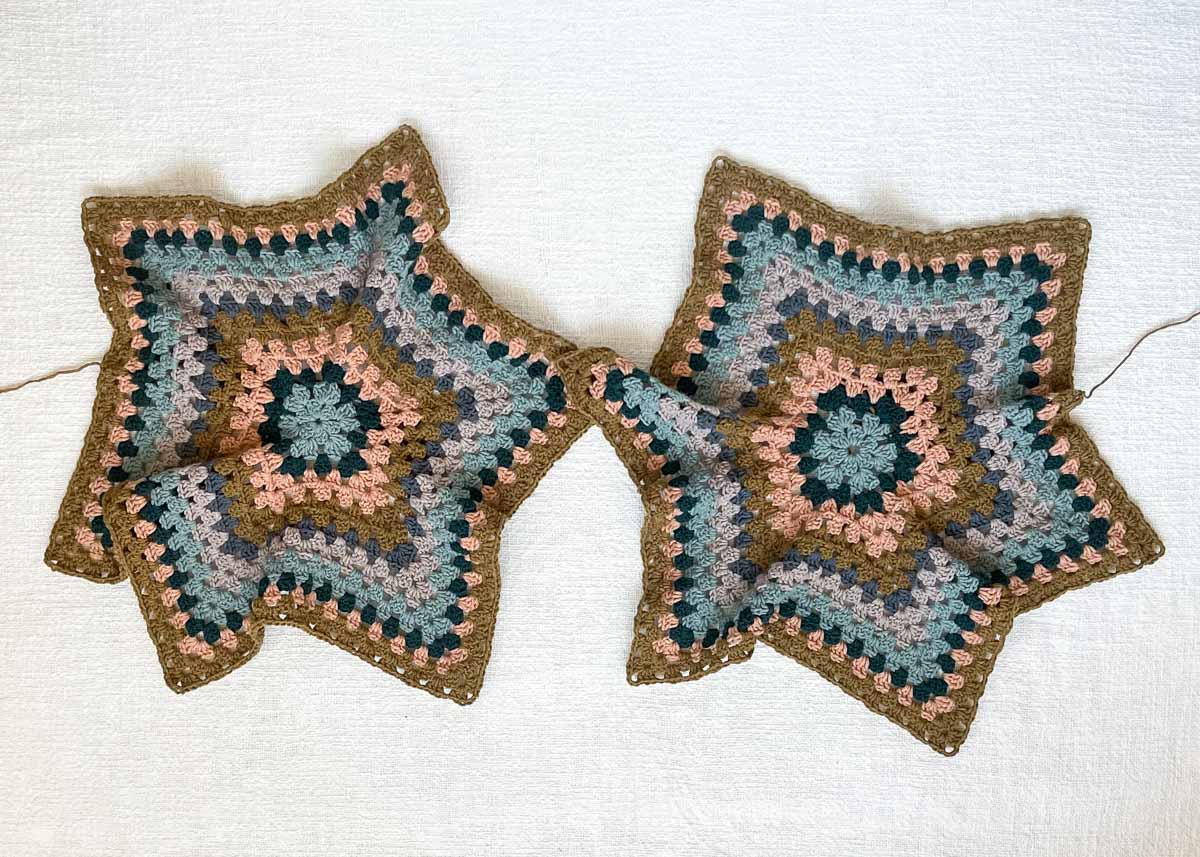 Two granny stitch crochet hexagons laying side by side.