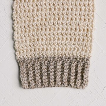 Crochet ribbed stitches along the edge of an off white swatch.