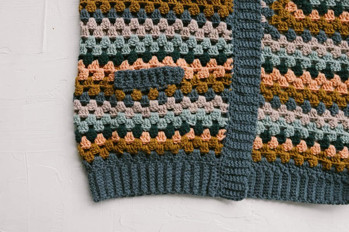 Crochet ribbed stitches along the edge of a granny stitch cardigan.
