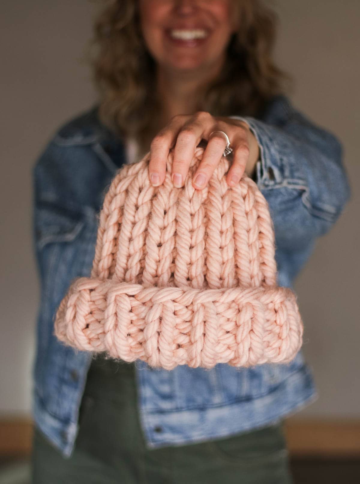 A knit ribbed hat made with chunky pink yarn.