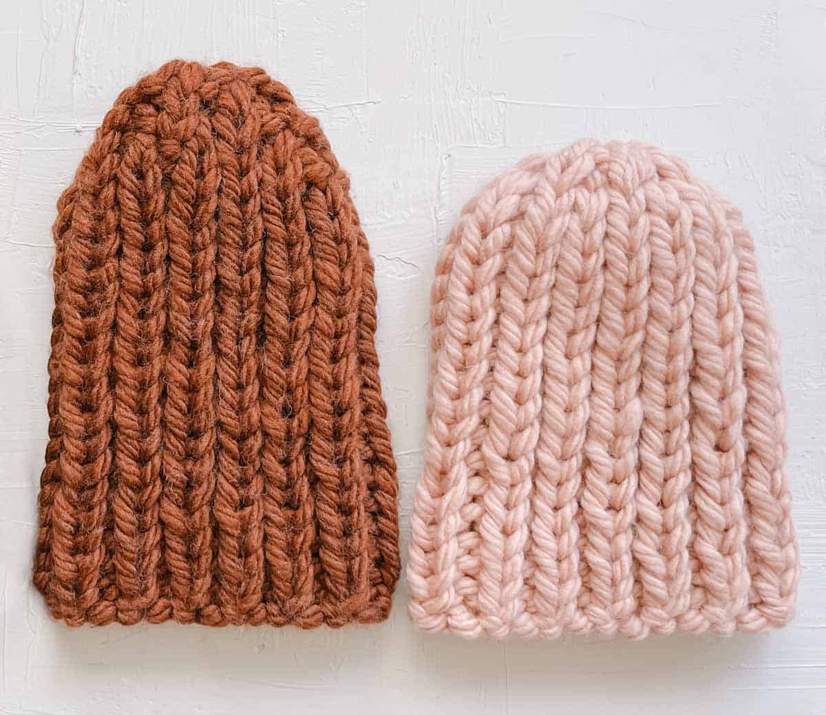 Two bulky knit hats next to each other on a white background.