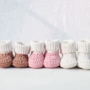 Crochet baby booties with folded over cuffs lined up.