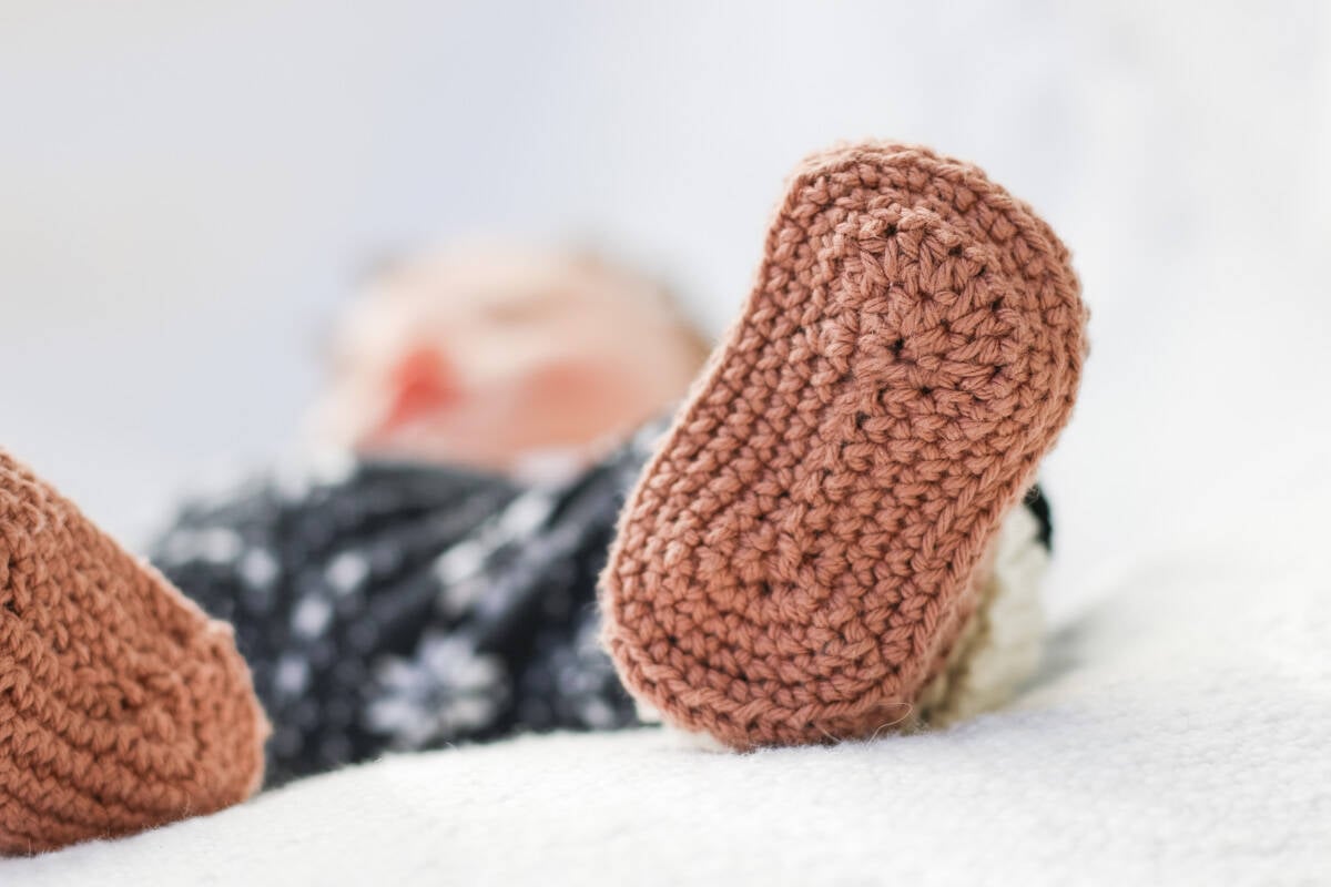 Bottom sole of crochet baby shoe on an infant.