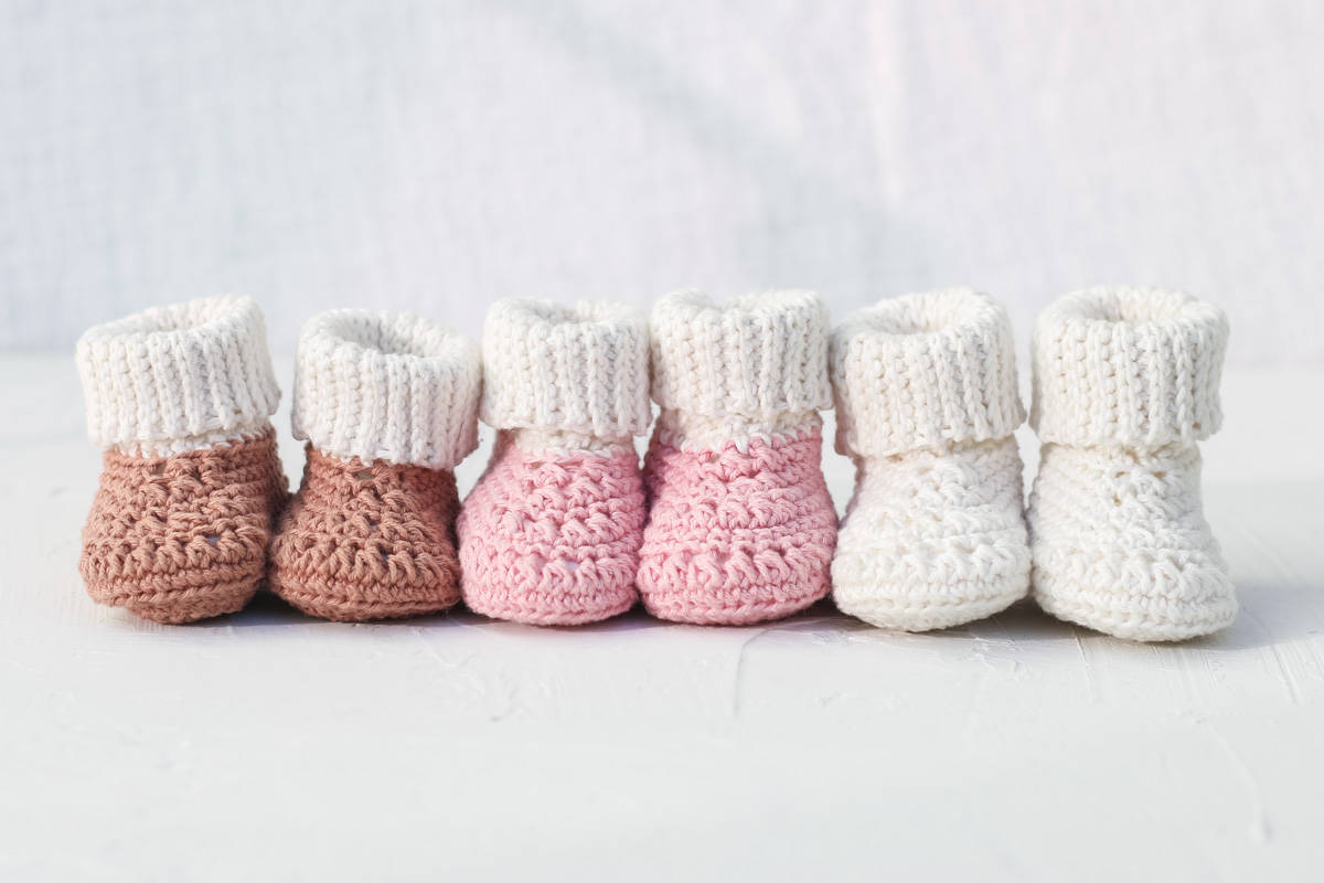 Three pairs of cute crochet baby booties with fold down cuffs.
