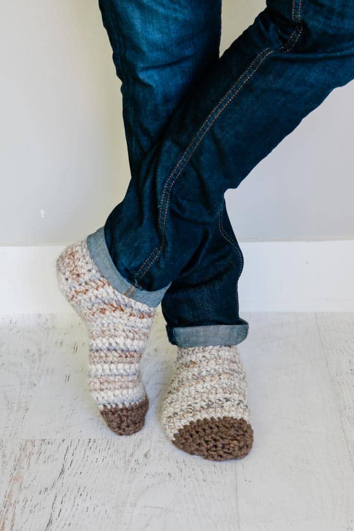 Men's legs and feet wearing a pair of crochet socks.