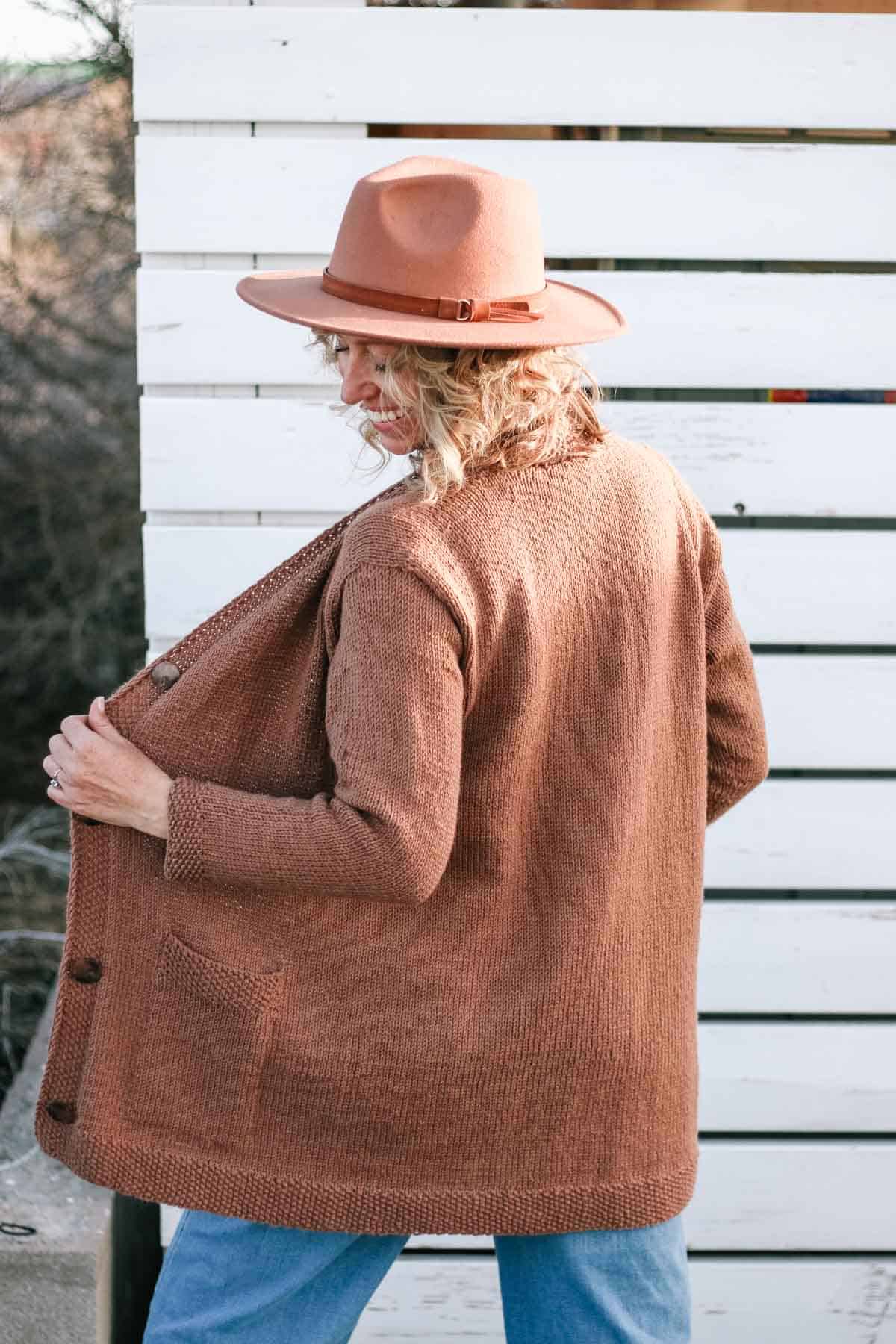 Back of knitted cardigan made with Lion Brand Color Theory yarn in the color Nutmeg.