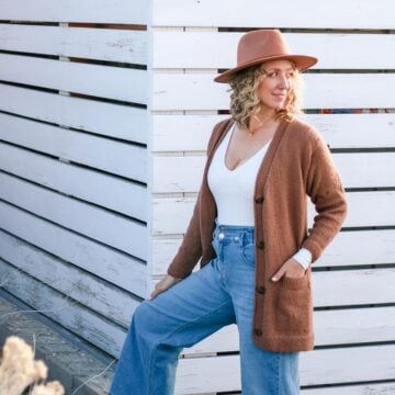 Knit cardigan with pockets and buttons, worn by a blond woman outdoors.