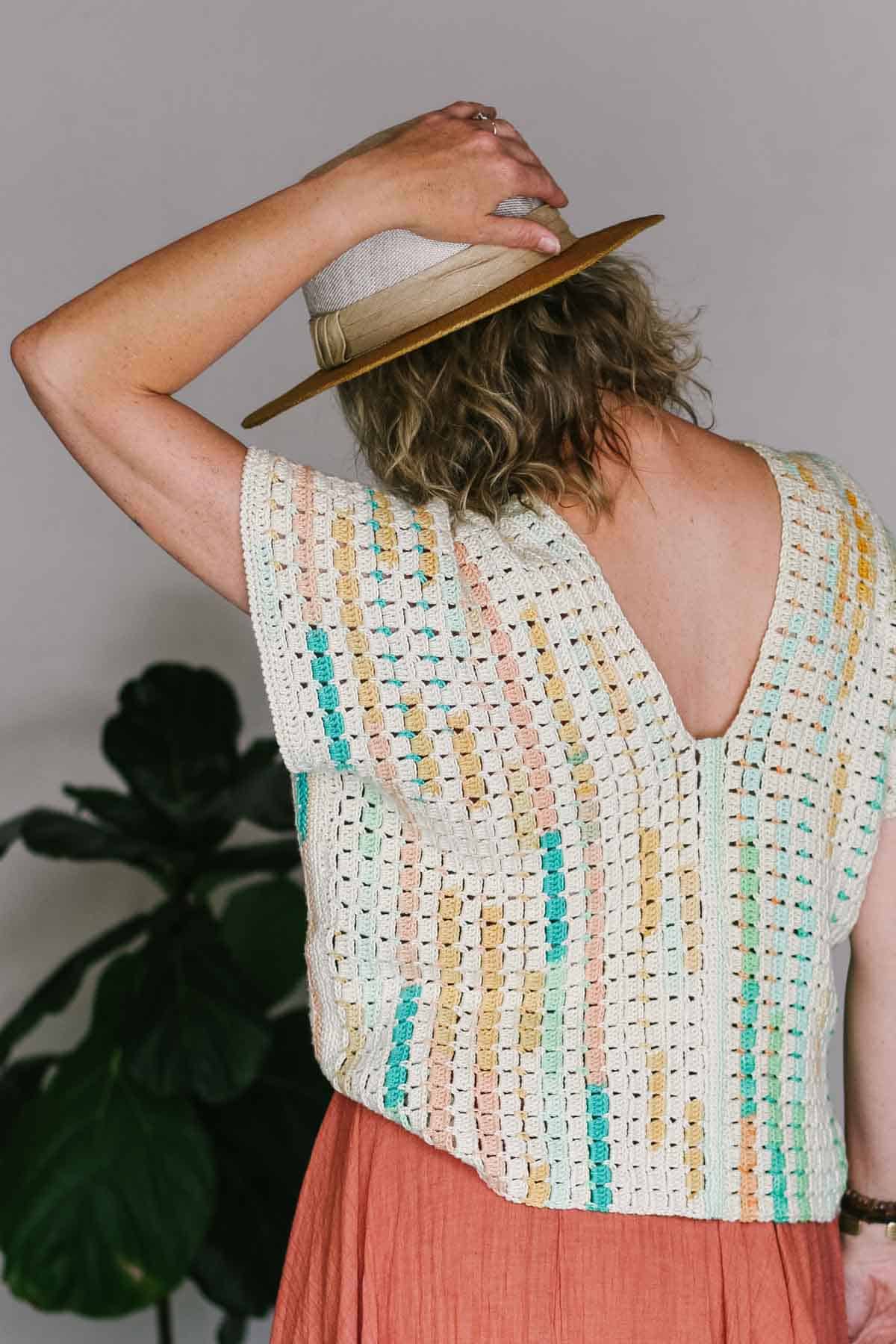 Crochet tee made from rectangles, modeled on a woman facing away.