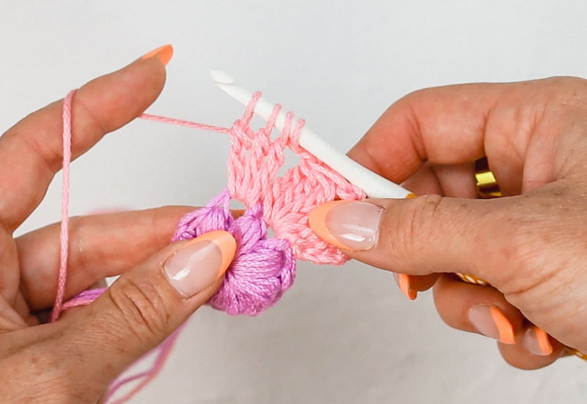 A crochet petal in progress made from three treble stitches.