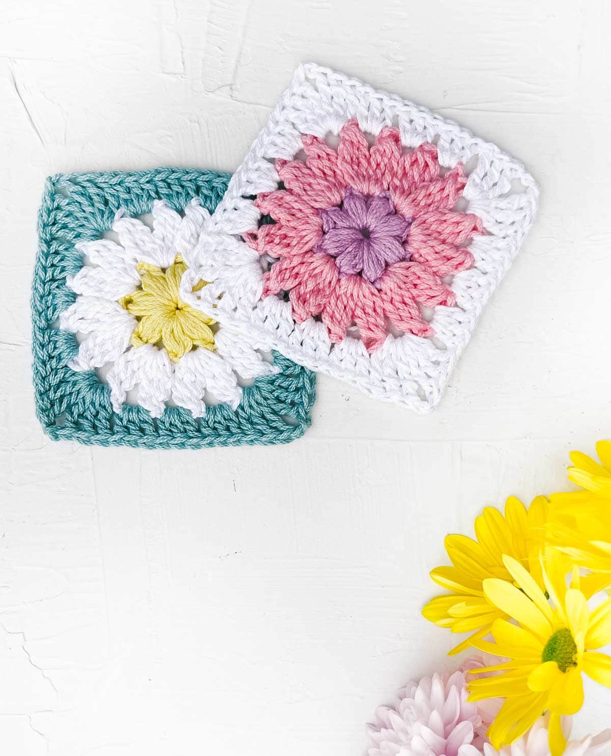 Two crocheted granny squares with round flower designs in the centers.