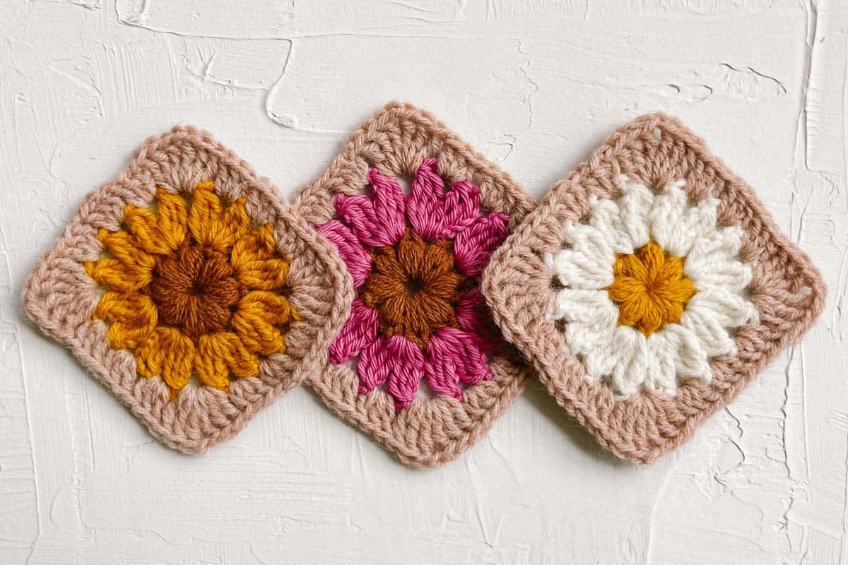 A crochet daisy square, zinnia square, and chrysanthemum square.