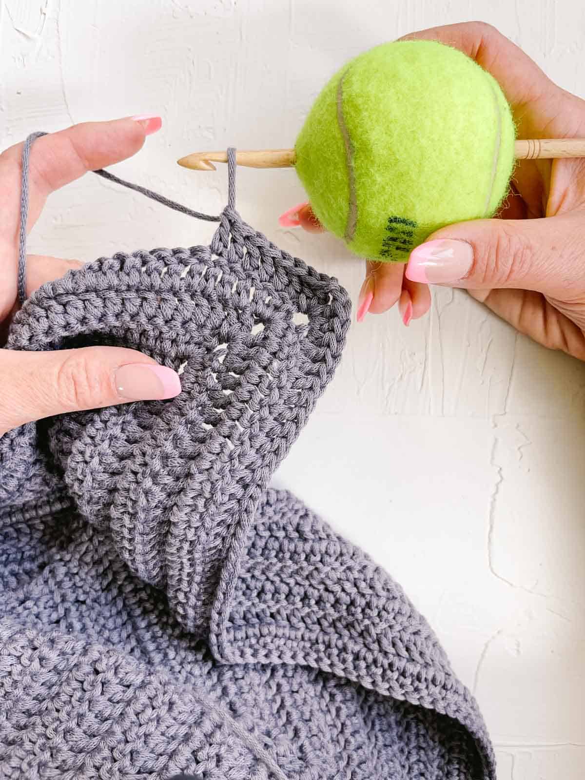 Crocheting with a DIY ergonomic crochet hook made from a tennis ball. 