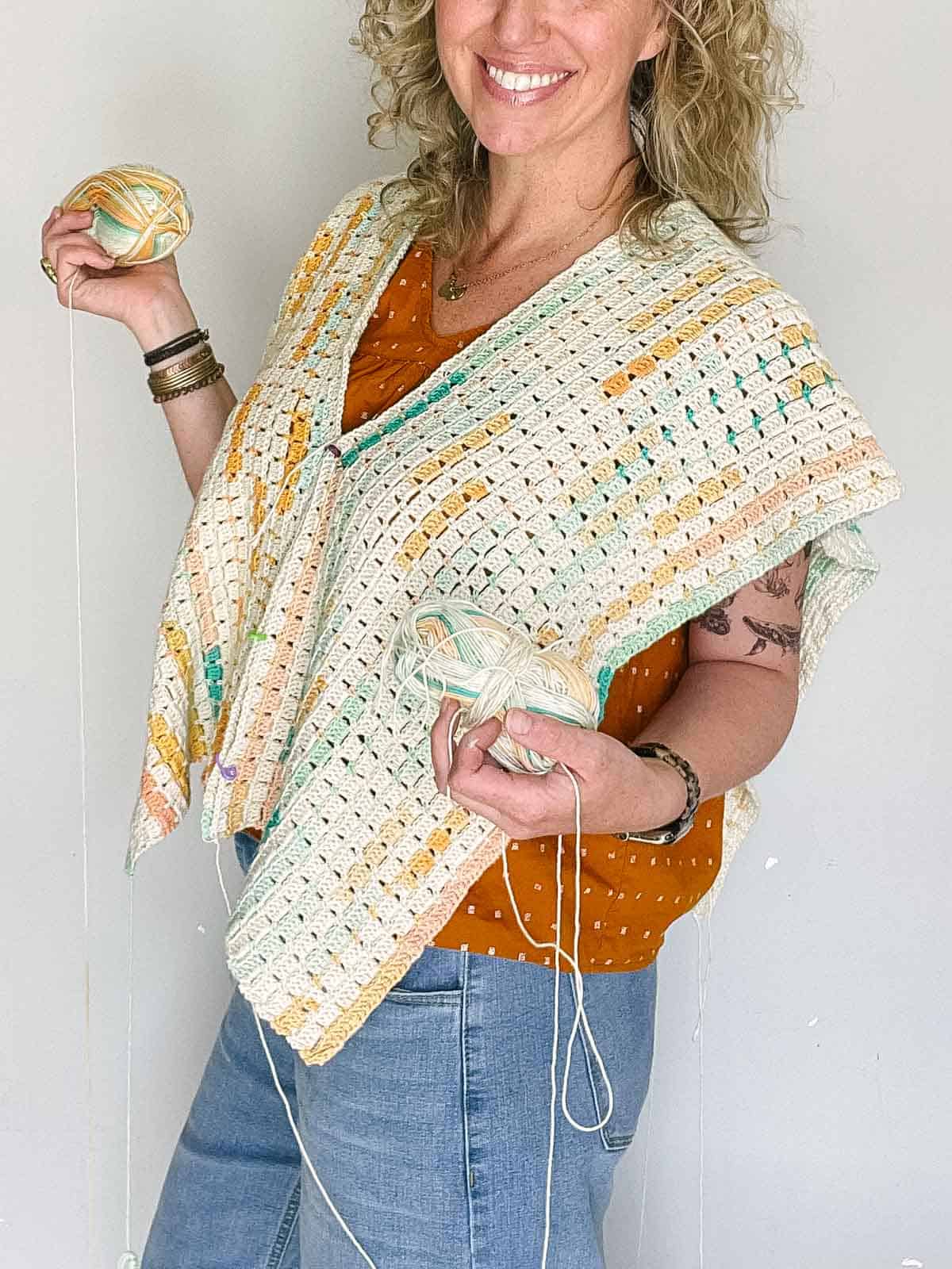 Jess Coppom wearing two crocheted rectangles that are pinned together to form a shirt.
