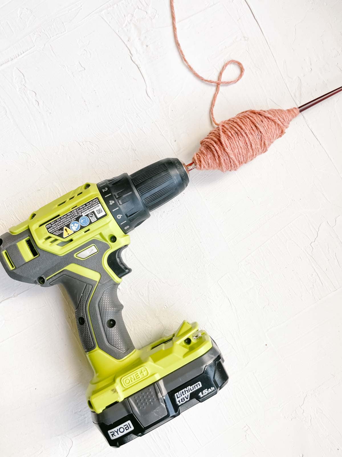 A power drill and stick being used to wind yarn quickly and easily. 