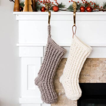 Chunky crochet Christmas stockings hanging from a mantle.