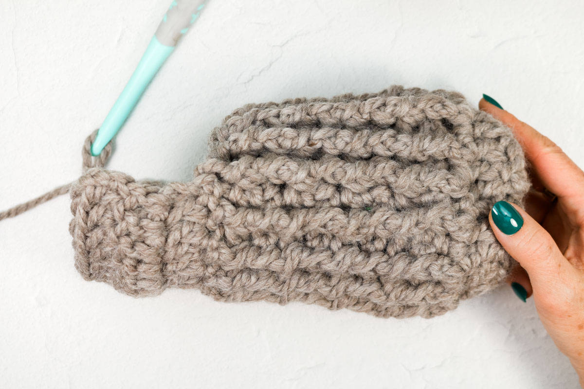 The toe of a crochet Christmas stocking with the heel in progress.