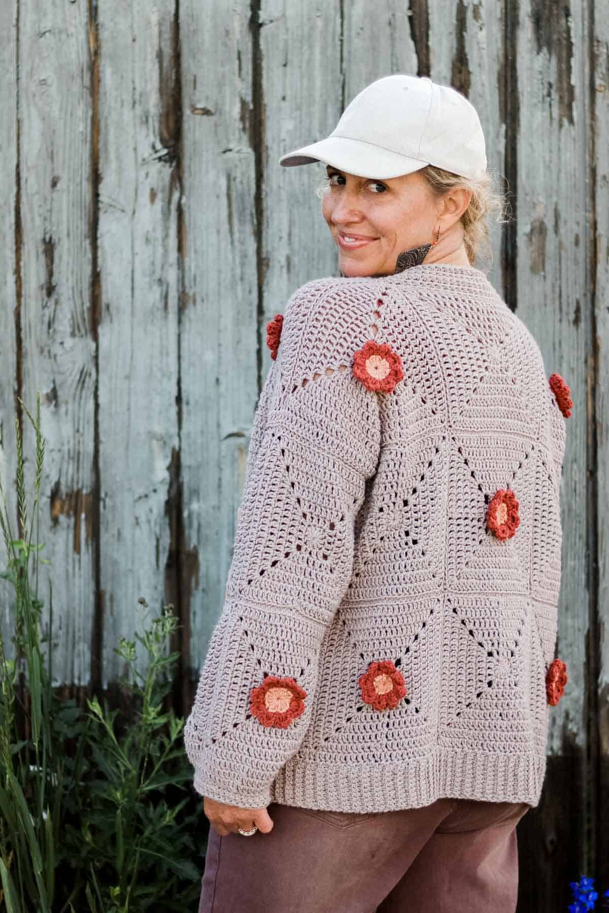 A flower cardigan worn by a blonde woman with her back to the camera.