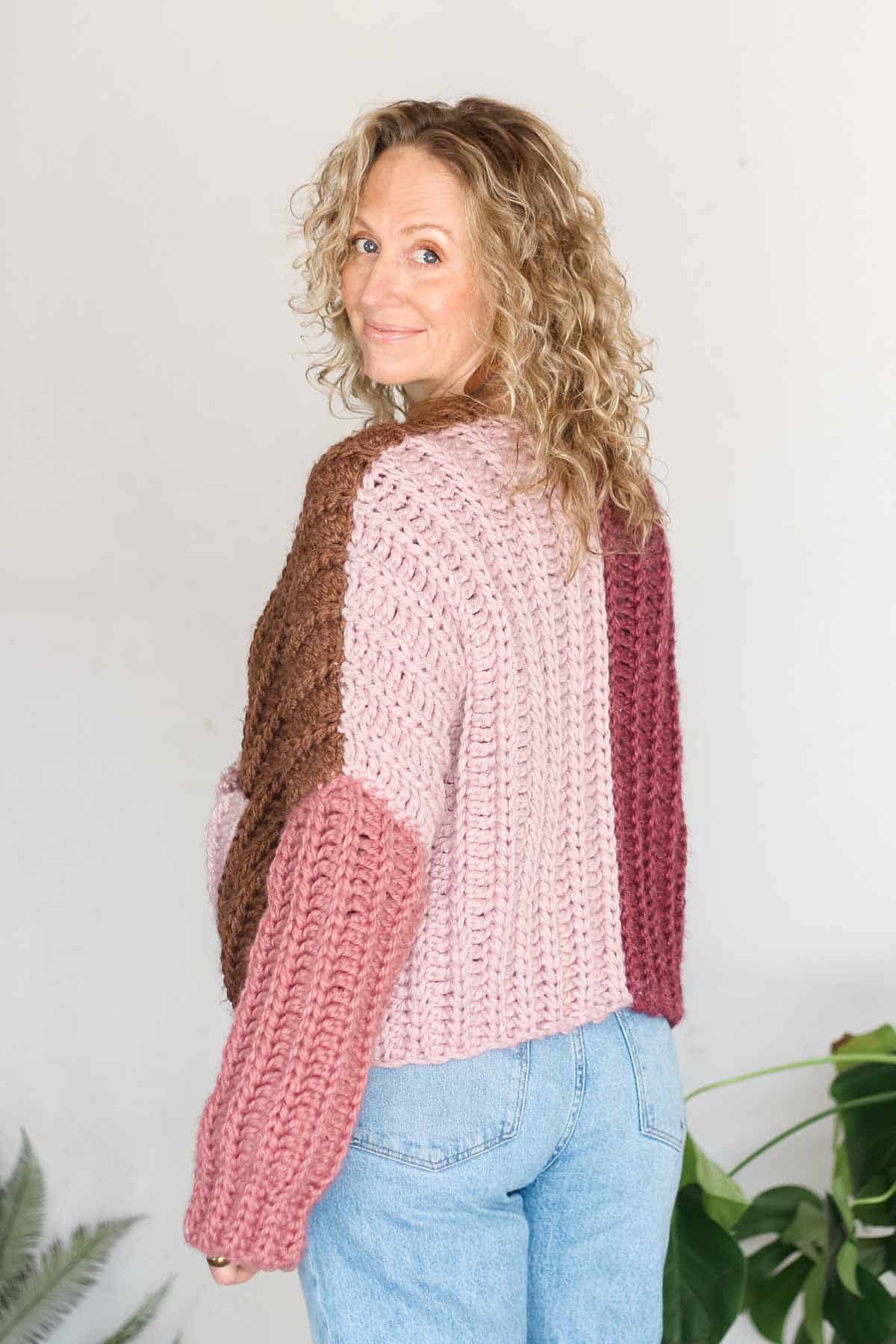 Back of a pink color-blocked crochet cardigan.