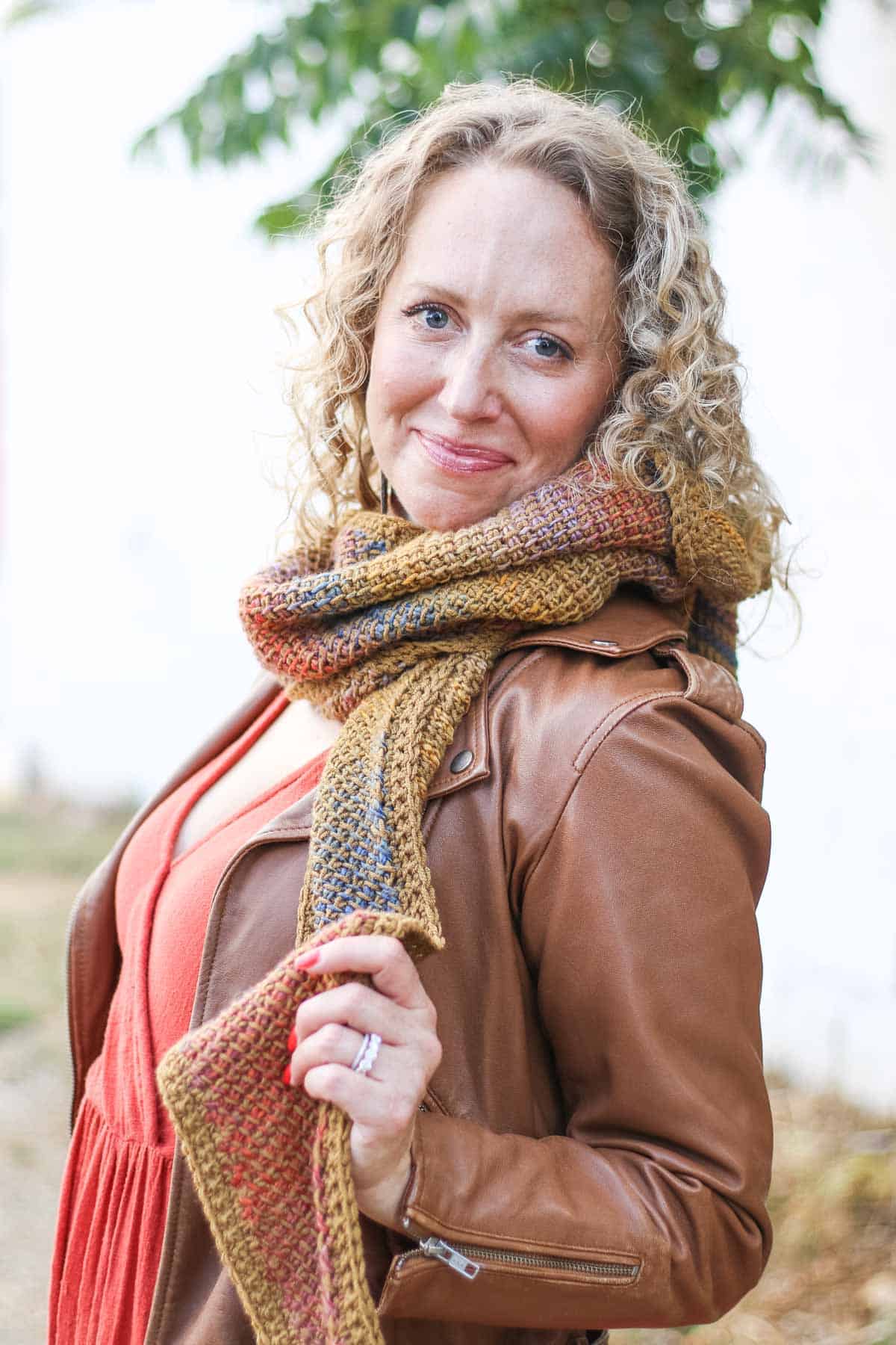 Jess Coppom modeling a Tunisian crochet scarf made with Lion Brand Ferris Wheel yarn.