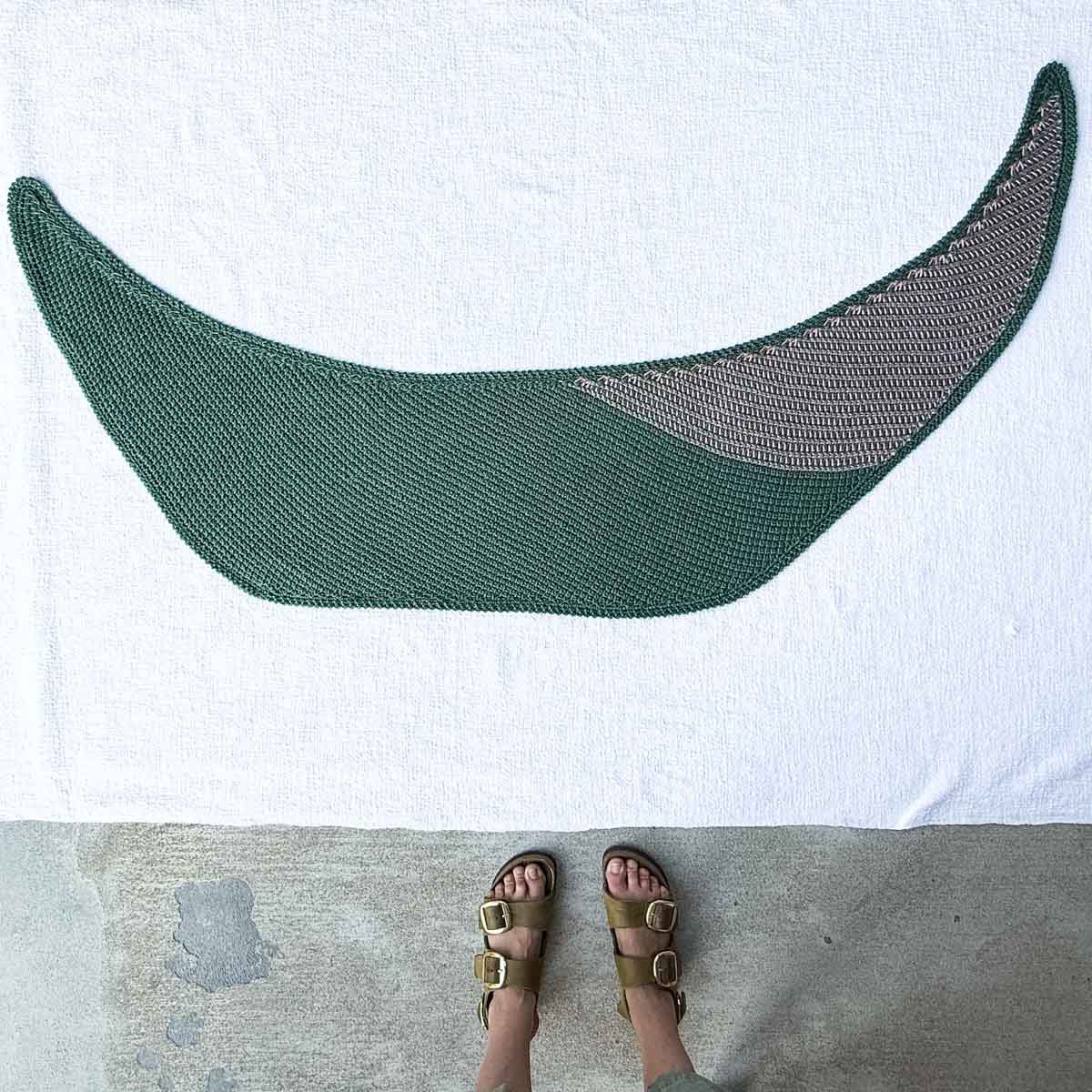 A Tunisian crochet boomerang scarf laid flat on a white background.