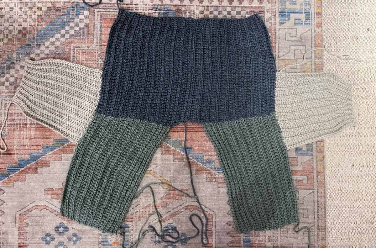 Chunky crochet cardigan in process of being seamed.