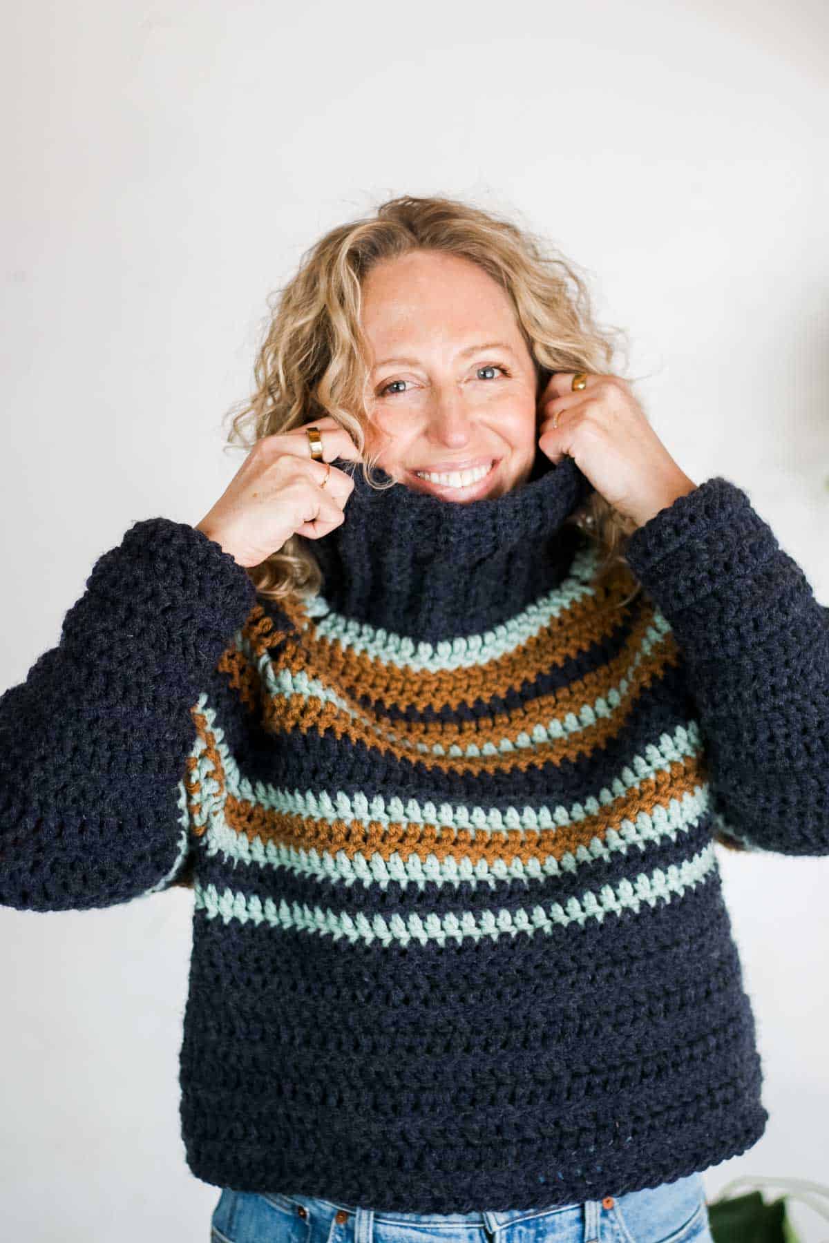 A striped, turtleneck raglan sweater made with double crochet stitches.