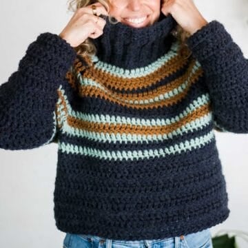 Striped chunky crochet raglan sweater with a turtleneck collar.