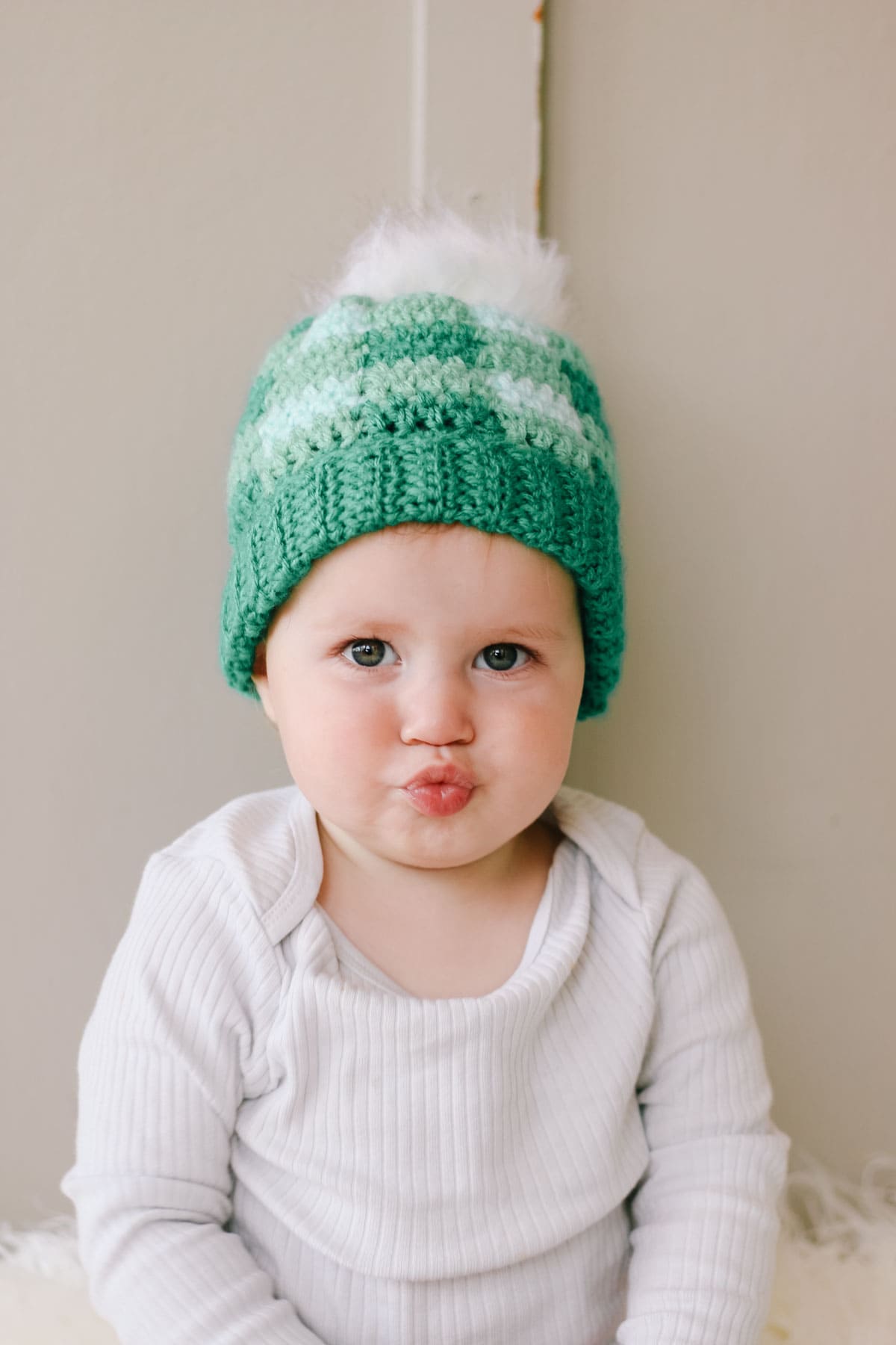 Green plaid crochet hat on a cute baby girl.