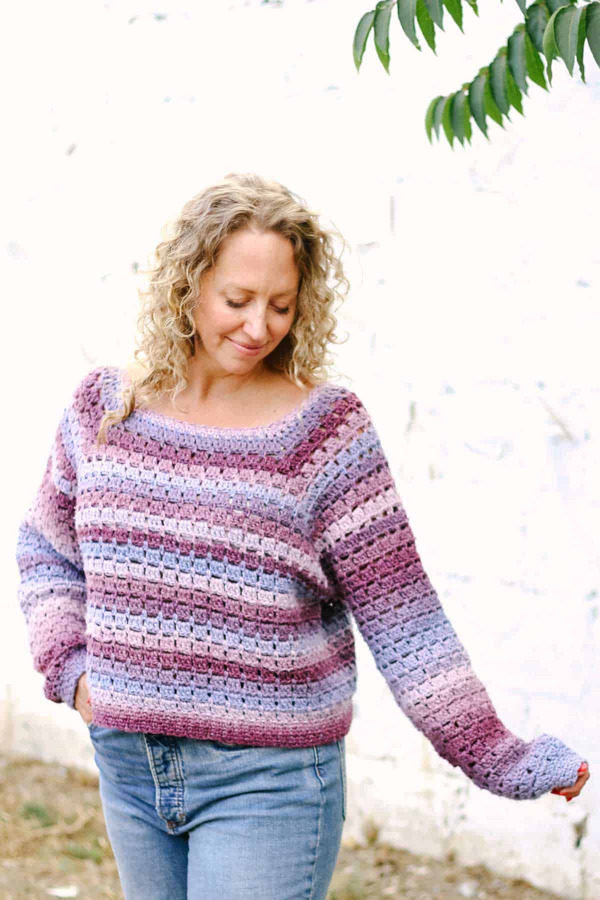 A loose, purple crochet pullover sweater worn by a blonde woman.