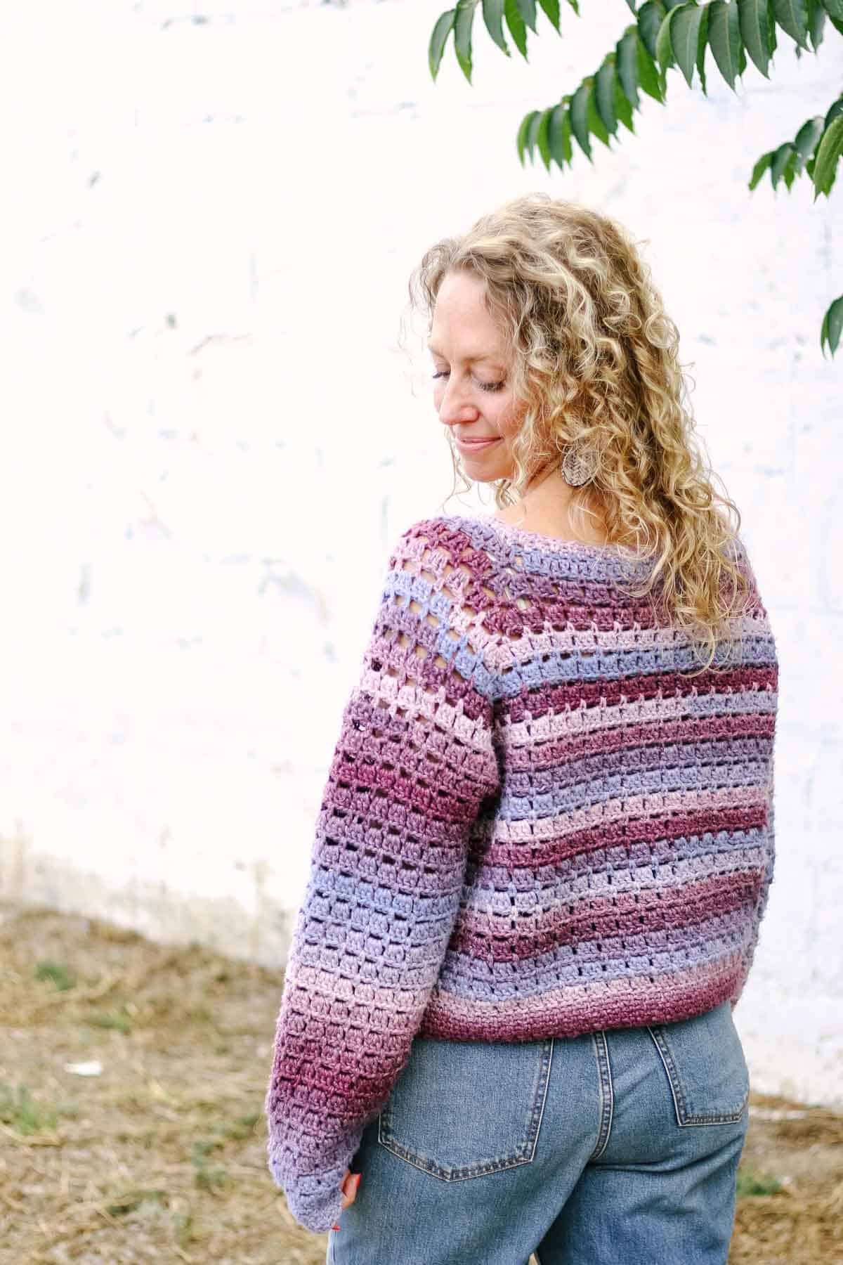 The back view of a block-stitch crochet raglan sweater.