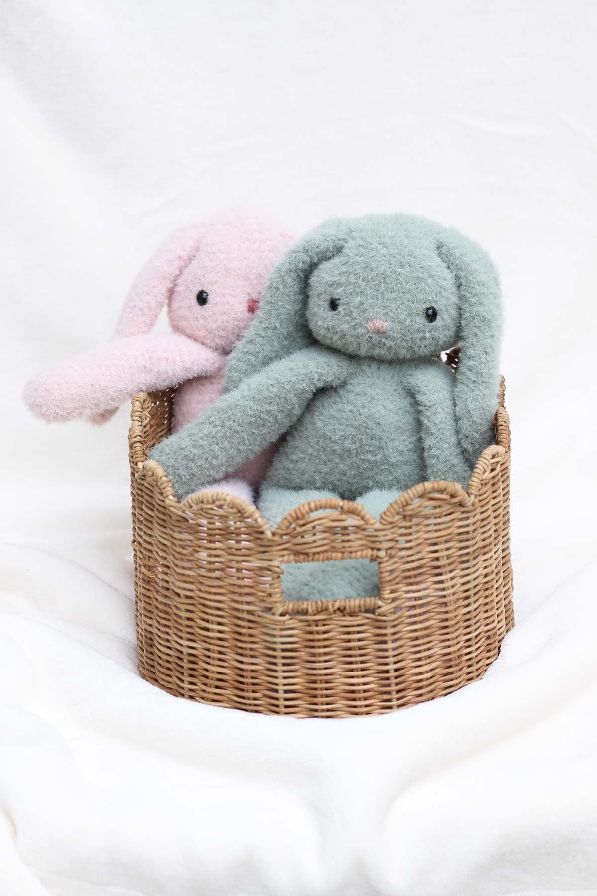 Two fuzzy crochet bunnies in an Easter Basket.
