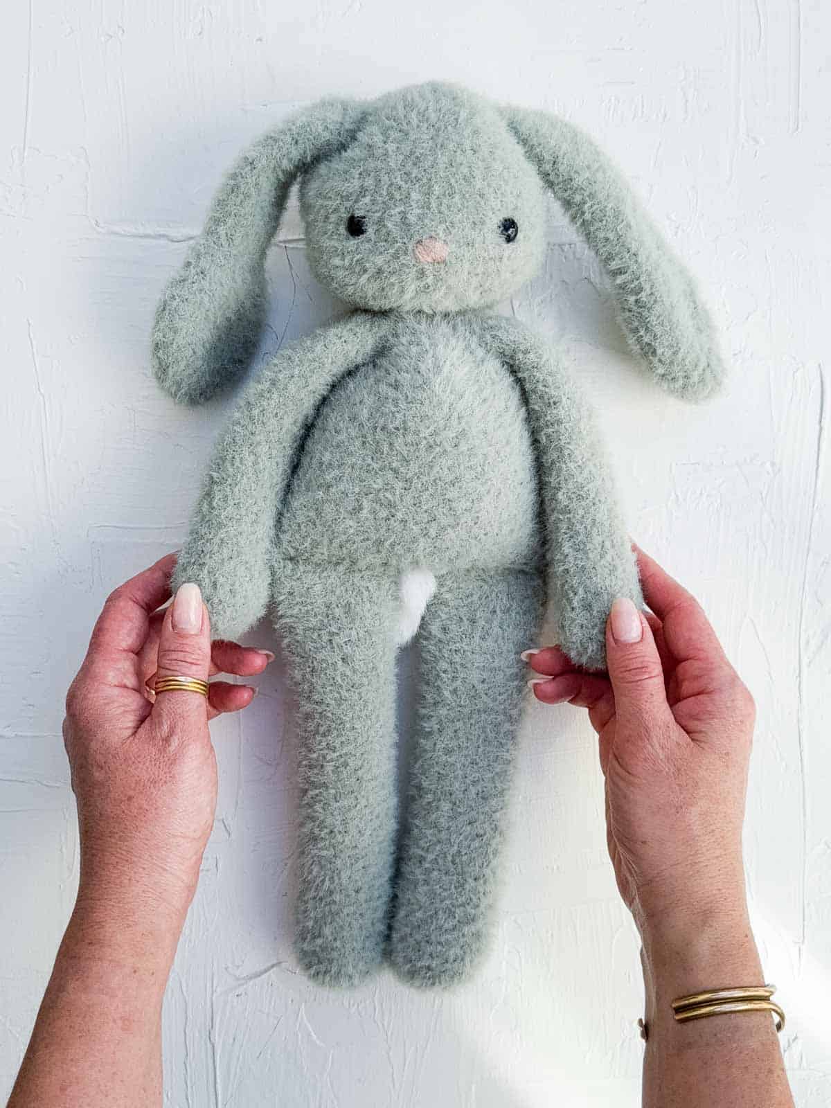 A crochet bunny with long legs on a white background.