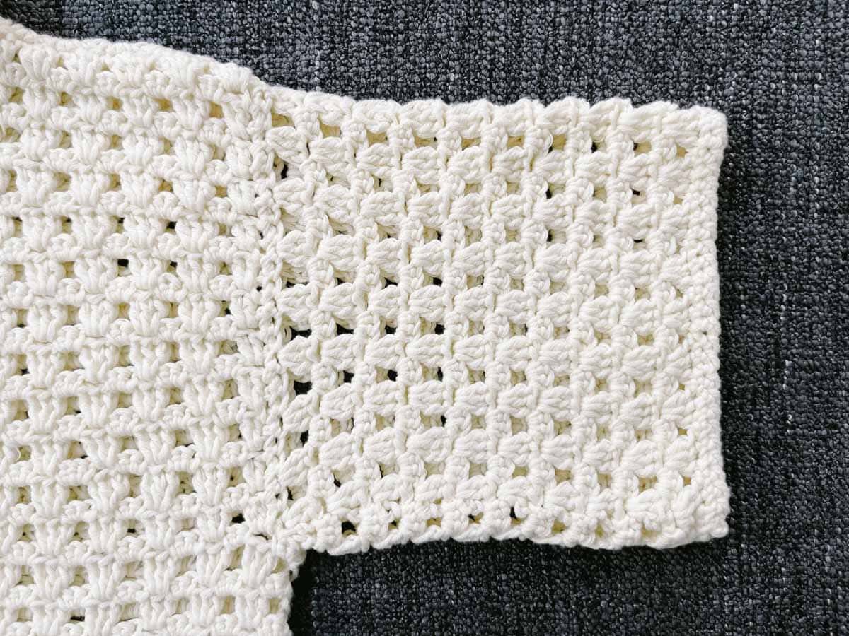 Sleeve of a lightweight crochet shirt.