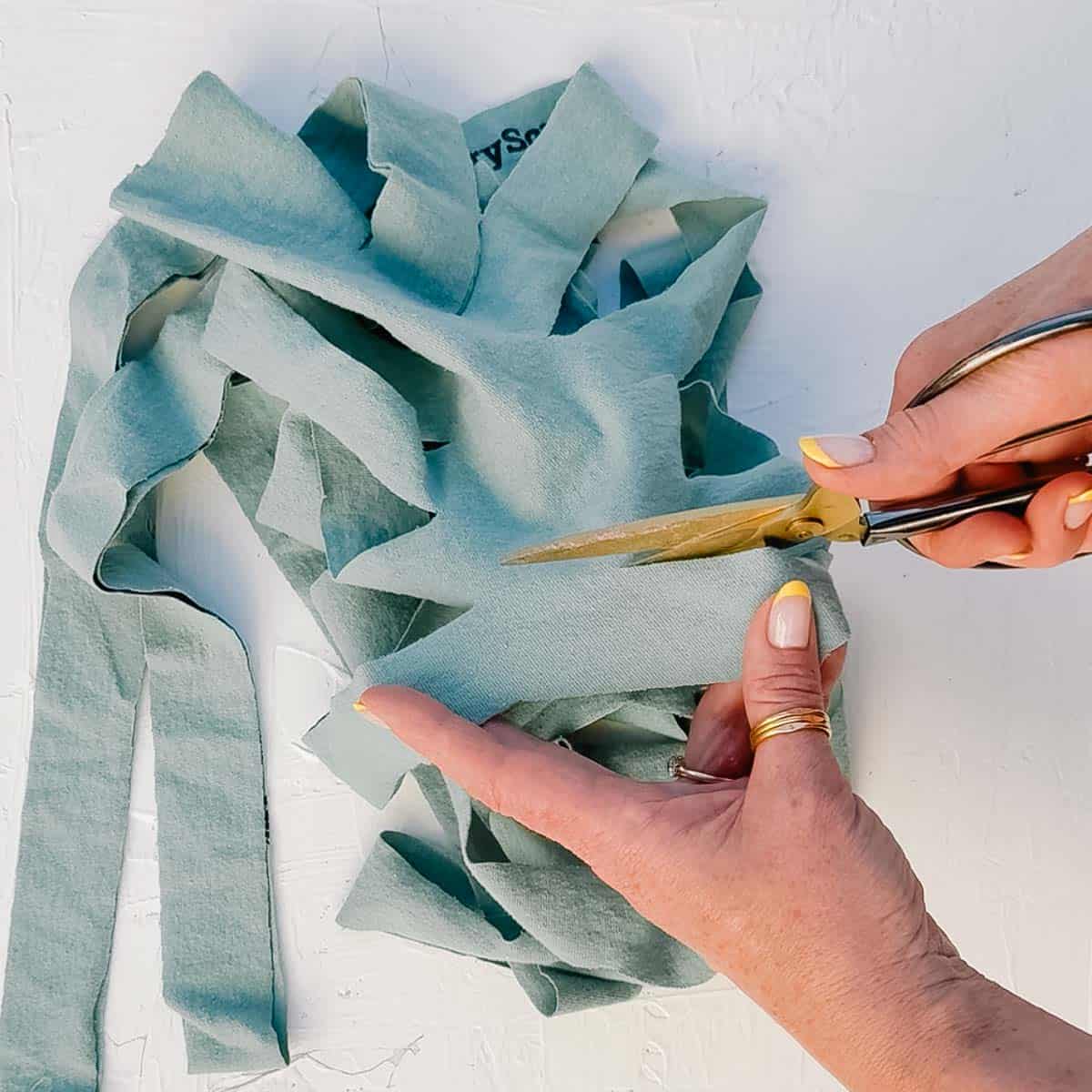 A t-shirt being cut into a long strand of t-shirt yarn.