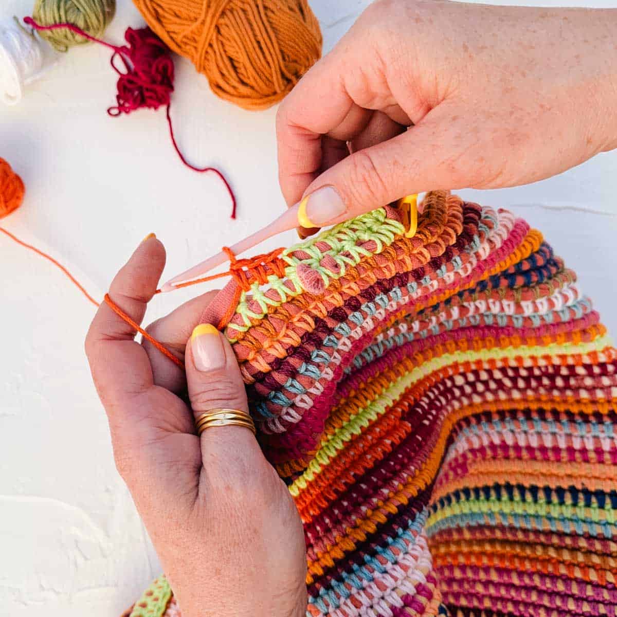 Color transition between stripes where yarn tails are crocheted over.