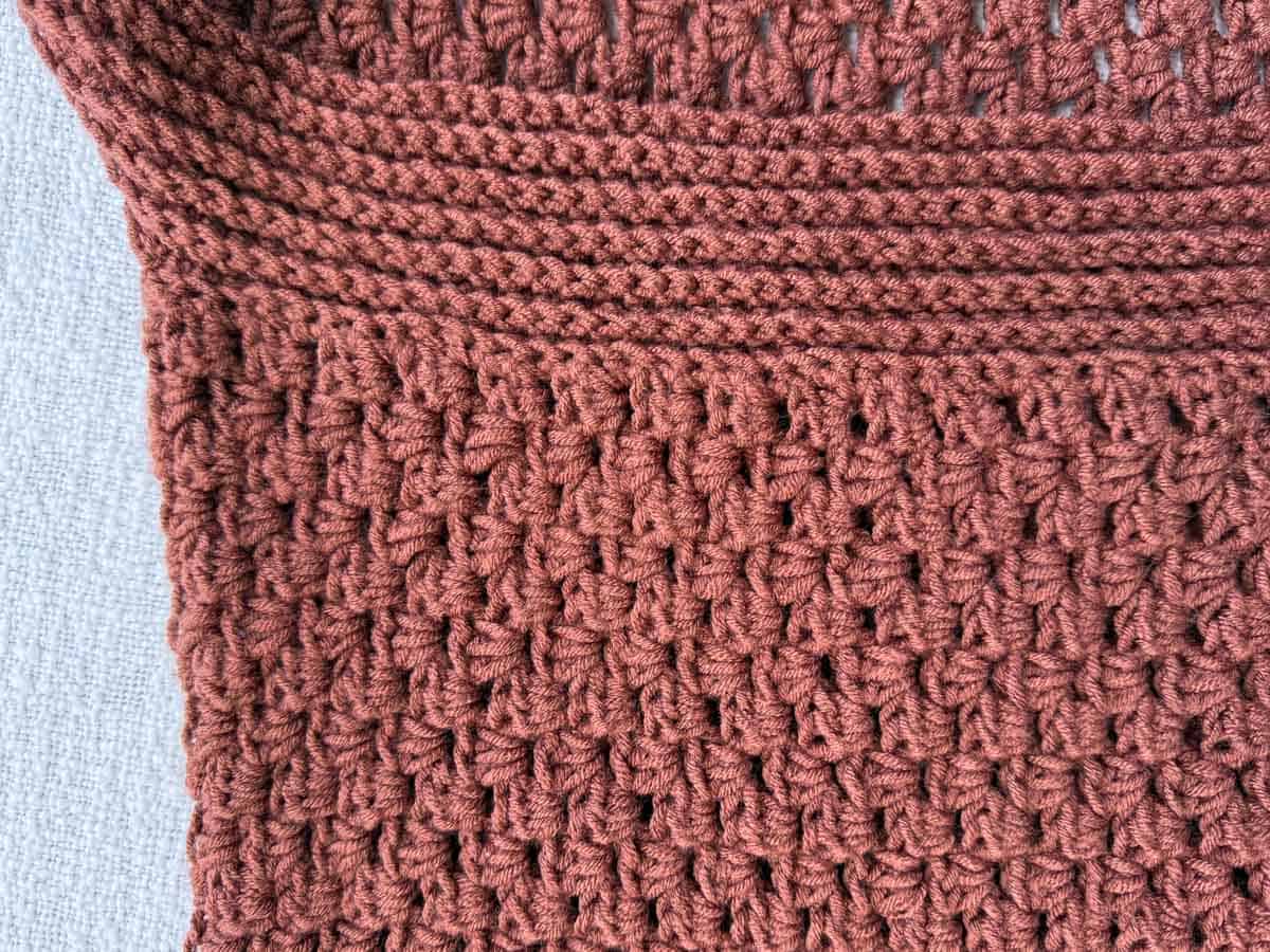 Detail shot showing the ribbed collar transitioning into the half double crochet body of the cardigan.