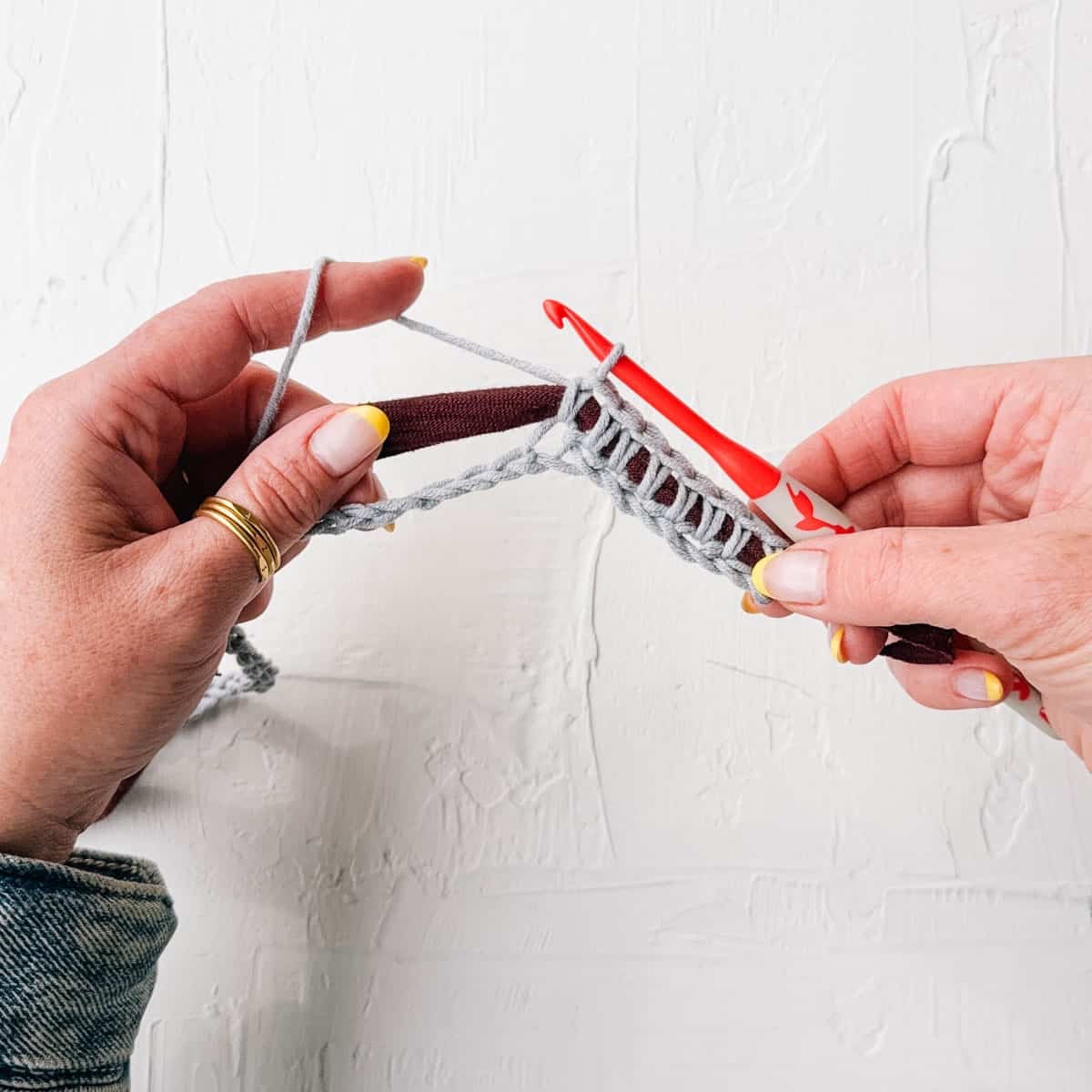 Scrap yarn being crocheted over t-shirt yarn core.